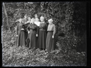 Six femmes (dont Mathilde Coutemoine, 2e à partir de la droite), un prêtre et un militaire posant dans la nature.