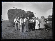 Groupe posant devant une charrette de foin attelée à des bœufs.