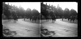 Hommes en uniforme à cheval à Lons-le-Saunier, une foule au loin.