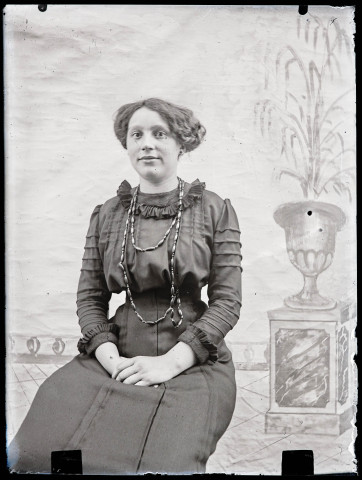 Portrait d'Agathe Rameaux assise devant un décor peint.