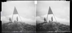 Deux femmes et un homme tenant un appareil photographique au sommet de la Dôle, au niveau de la mire du point géodésique.