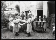 Groupe de jeunes filles apprenant à faire la lessive, dans la cour de l'école Saint-Laurent de Vers-en-Montagne.