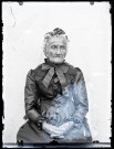 Portrait assis d'une femme âgée portant une coiffe à dentelle.