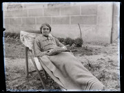 Portrait d'une femme lisant, assise avec une couverture en extérieur.