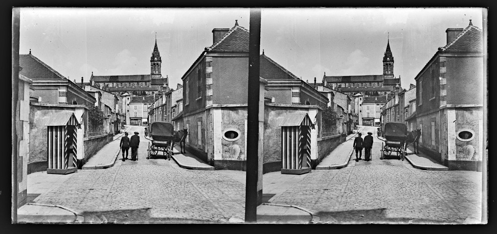 Calèche et passants dans une rue de Berne, une guérite au premier plan et une église en arrière plan.