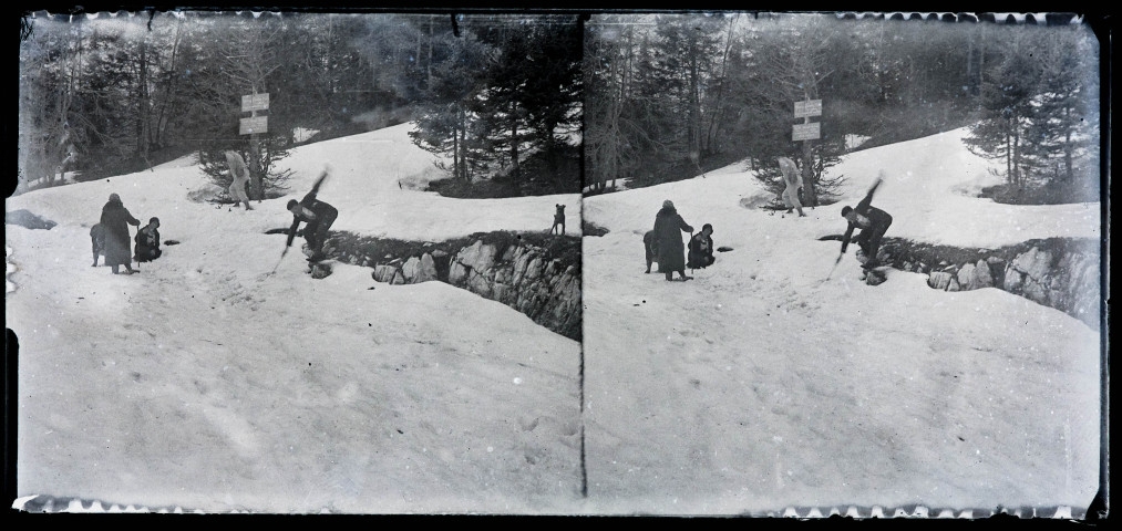 Personnes dans la neige en bordure de forêt, au niveau d'un panneau indicateur.