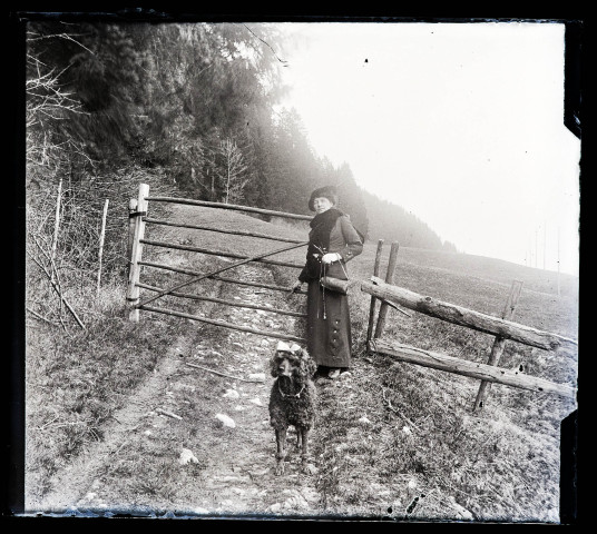 Emilie Vuillaume devant une barrière avec son chien Coquette.