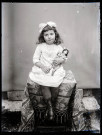 Portrait d'une fillette tenant une poupée.