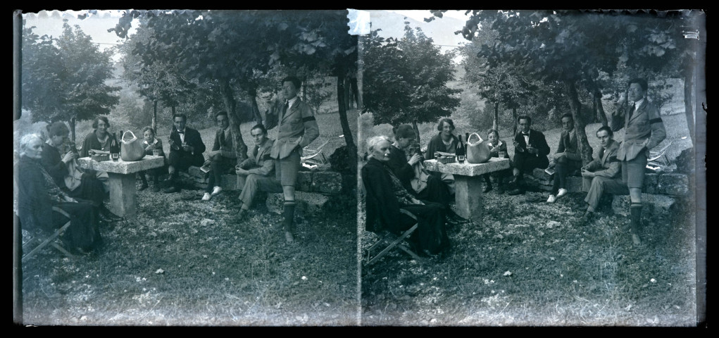 Groupe buvant en extérieur, sous les arbres, et portant le deuil. Anne Coutemoine est assise à l'extrême gauche, son fils Jean Rameaux fume la pipe au centre.