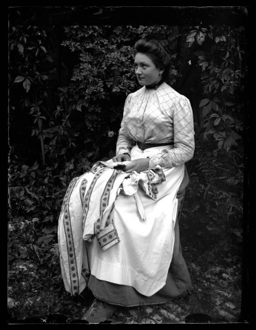 Portrait d'une jeune femme faisant de la couture en extérieur.