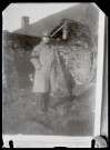 Reproduction d'un cliché d'un soldat debout devant une maison.
