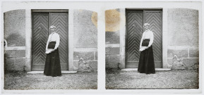 Portrait d'Agathe Coutemoine devant la porte d'un bâtiment, un journal entre les mains.