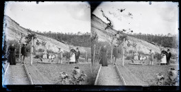 Hommes, femmes et enfants dans les allées d'un potager.