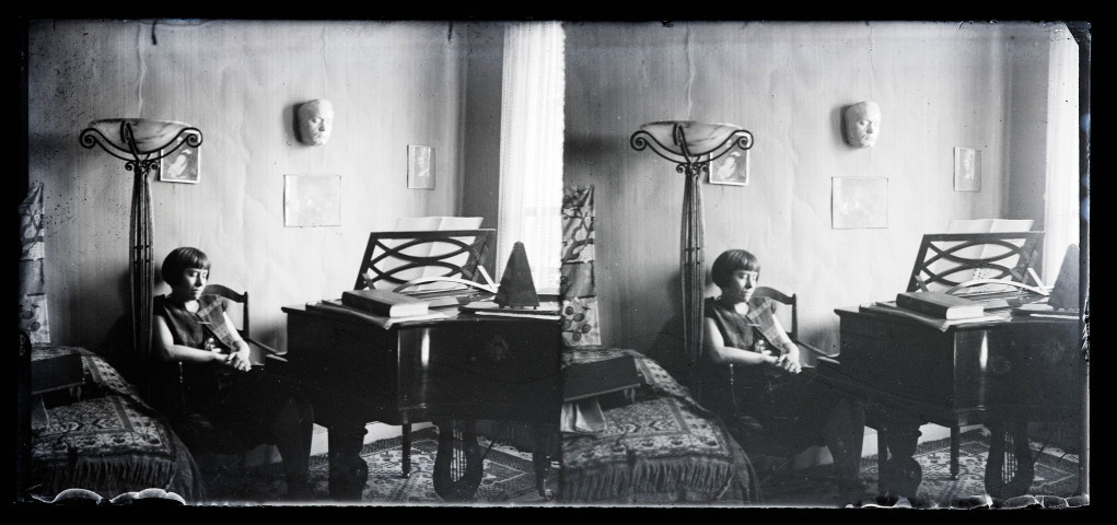 Jeune femme assise dans un intérieur décoré, près d'un piano.