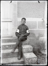 Portraits du Corps des forestiers canadiens et autres troupes : militaire du service médical du 165e bataillon canadien assis sur une marche.