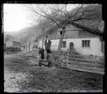 Femme âgée près d'une fontaine et Emilie Vuillaume, épouse d'Elisée Coutemoine, assiste sur un tronc d'arbre devant une maison.