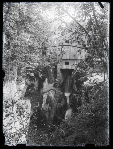 Bâtiment en bois au-dessus d'une cascade.