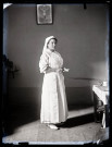 Portrait d'une infirmière debout, des papiers dans les mains.