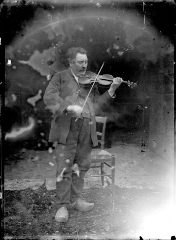 Un homme jouant du violon chaussé de sabot