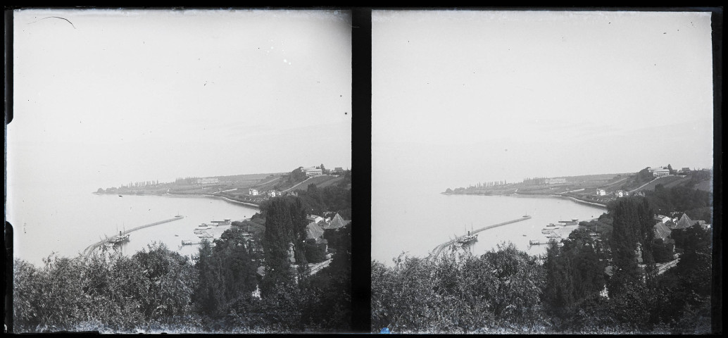 Habitations surplombant un lac avec port et jetée.