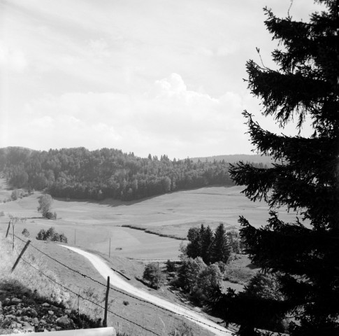 Vue générale avec chemin serpentant dans la campagne au premier plan.