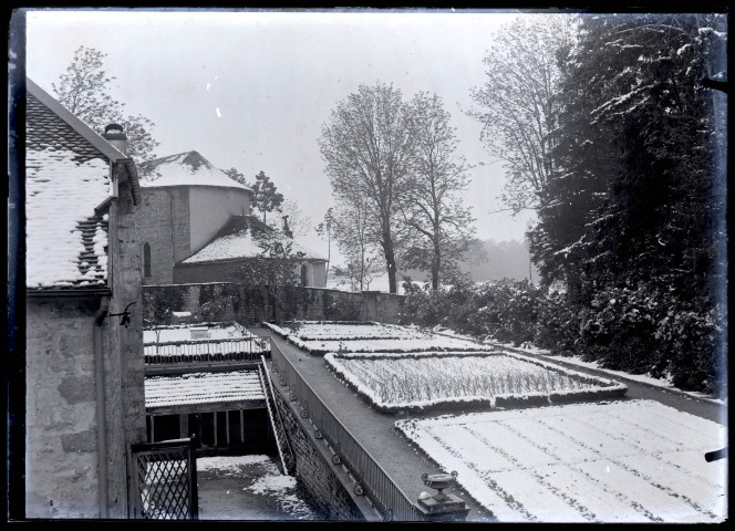 Bâtiments et potager sous une fine couche de neige à Vers-en-Montagne.