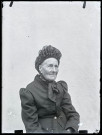 Portrait assis d'une femme âgée portant une coiffe.