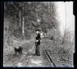 Emilie Vuillaume en promenade avec son chien Coquette sur un chemin arboré.