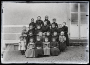 Classe de filles, Agathe Coutemoine assise au milieu de ses jeunes élèves.