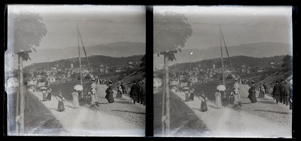 Promeneurs sur un chemin, un village au loin.