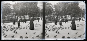 Emilie Vuillaume entourée de pigeons sur une place passante.