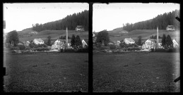 Paysage du Doubs avec quelques maisons et une cheminée d'usine.