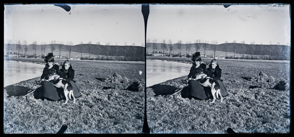 Emilie Vuillaume et Agathe Coutemoine assises au bord d'un cours d'eau avec un chien.