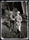 Portrait d'un cavalier tenant un cheval par les rênes.