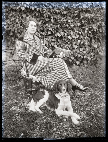 Portrait d'une jeune femme assise en extérieur avec un chien.