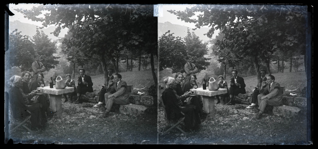 Groupe buvant en extérieur, sous les arbres, et portant le deuil. Anne Coutemoine est assise à l'extrême gauche, son fils Jean Rameaux fume la pipe au centre.