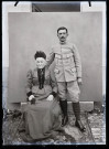 Portrait d'un militaire debout à côté d'une femme âgée assise.