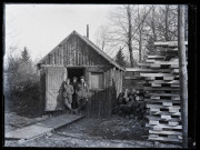 Exploitation de la forêt de la Joux par les soldats canadiens : trois militaires à la porte d'un baraquement en bois.