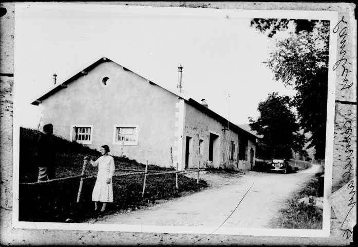 Reproduction. Deux personnes devant une maison Lambey. Cerniébaud